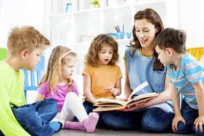 Teacher Working with Kids on Reading