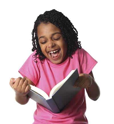 Little girl giggling while reading a funny book